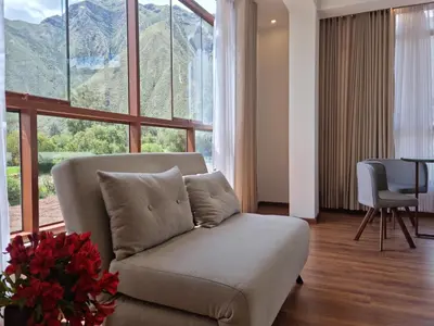 a living room with a couch and a large window at Flores de la Villa in Huayoccare