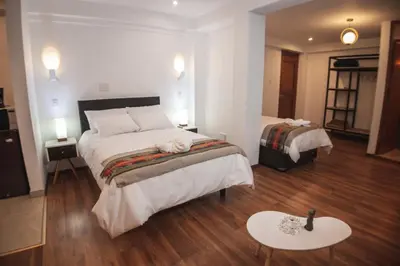 a hotel room with two beds and a table at Flores de la Villa in Huayoccare