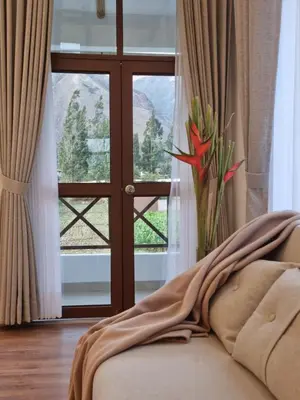 a couch with a blanket on it in front of a window at Flores de la Villa in Huayoccare