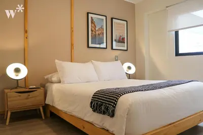 a bedroom with a bed with two lamps and a window at Solar by Wynwood House in Lima