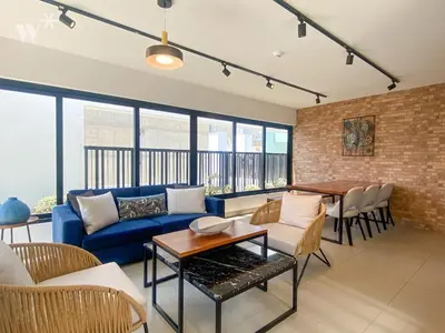 a living room with a blue couch and a brick wall at Solar by Wynwood House in Lima