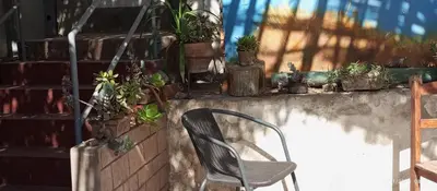 a chair sitting next to a brick wall with potted plants at Departamento 6p Tierra del Sol Eterno - Ica centro in Ica