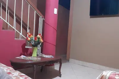 a vase of flowers on a table next to a staircase at Departamento 6p Tierra del Sol Eterno - Ica centro in Ica