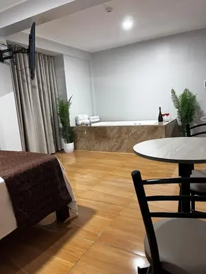 a room with a bed and a table and a table at COSMOPOLITAN INN in Ventanilla