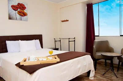 a hotel room with a bed with a tray of food on it at COSMOPOLITAN INN in Ventanilla