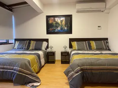 a bedroom with two beds and a painting on the wall at 18 Departamento en la mejor zona de Miraflores in Lima