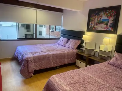 a bedroom with two beds and a picture on the wall at 17 Dpto con inmejorable ubicación Miraflores in Lima