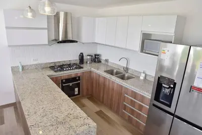 a kitchen with a refrigerator and a counter top at Casa de playa: Disfruta de grandes momentos y del sol todo el año en Paracas in Paracas