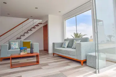 a living room with two couches and a table at Casa de playa: Disfruta de grandes momentos y del sol todo el año en Paracas in Paracas