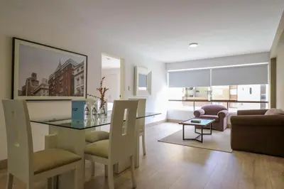a living room with a glass table and chairs at San Martin 598 by Wynwood House in Lima
