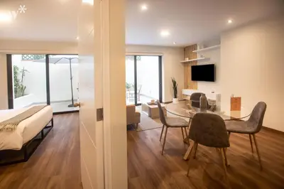 a bedroom and living room with a bed and a table and chairs at Alcanfores 1262 by Wynwood House in Lima