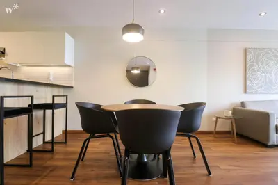 a dining room with a table and black chairs at Alcanfores 1262 by Wynwood House in Lima