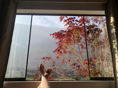 a person sitting in a window with their feet up at Casa Hotel Mamaluna in Lunahuaná