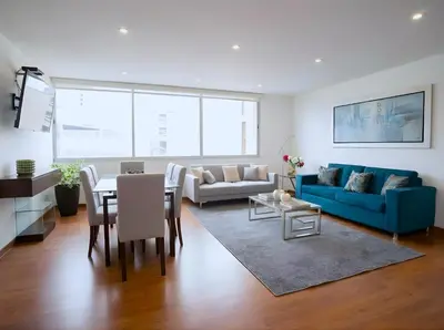 a living room with a blue couch and a table at Apartment in Center of Miraflores in Lima