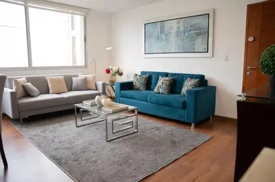 a living room with a blue couch and a table at Apartment in Center of Miraflores in Lima