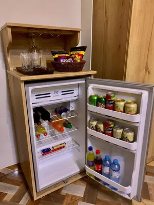 a small refrigerator with its door open in a kitchen at Cesars Hotel Lima in Lima