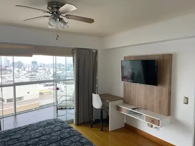 a bedroom with a bed and a flat screen tv at Book in Miraflores - Lima in Lima