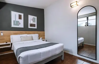 a bedroom with a large white bed and a mirror at TARATA BOUTIQUE HOTEL in Lima