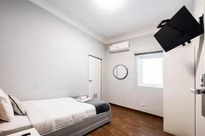 a white bedroom with a bed and a window at TARATA BOUTIQUE HOTEL in Lima