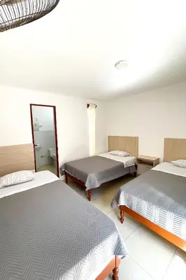 a bedroom with two beds and a mirror at LAS PALMERAS HOSTAL in Barranca