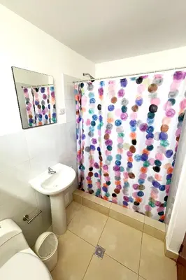 a bathroom with a toilet and a shower curtain at LAS PALMERAS HOSTAL in Barranca