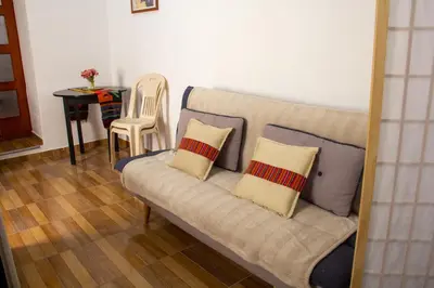 a couch in a living room with two pillows on it at Santo Domingo in Ayacucho