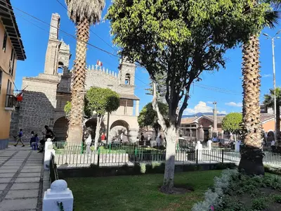 a white fire hydrant in front of a building at Santo Domingo in Ayacucho