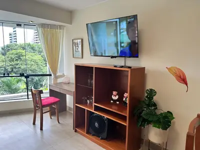 a living room with a flat screen tv on the wall at Bonito depa san isidro cama queen home office wifi y cochera in Lima