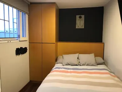 a bedroom with a bed with a headboard and a window at Departamento Cool & Comodo, San Isidro in Lima