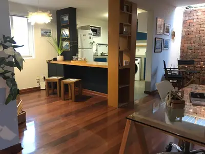 a kitchen and living room with wooden floors and a counter at Departamento Cool & Comodo, San Isidro in Lima