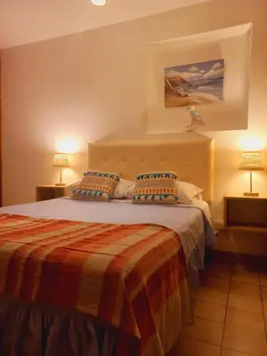 a bedroom with a large bed with two lamps at VIVEMAR PUNTA HERMOSA - Beach House Lima - Perú in Punta Hermosa