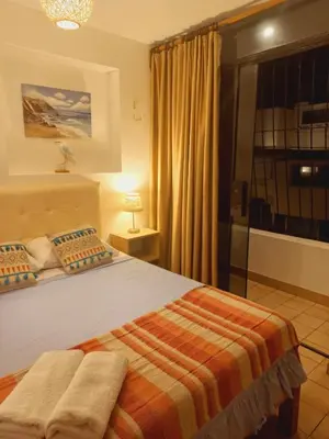 a bedroom with a bed and a large window at VIVEMAR PUNTA HERMOSA - Beach House Lima - Perú in Punta Hermosa