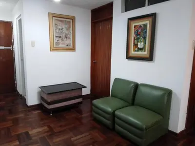 a living room with a green couch and a table at BONITO DEPARTAMENTO EN MIRAFLORES in Lima