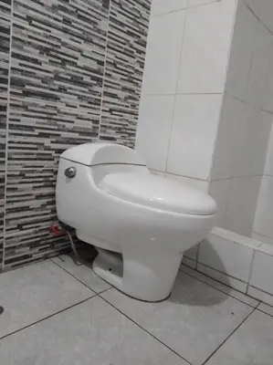 a white toilet in a bathroom with a brick wall at BONITO DEPARTAMENTO EN MIRAFLORES in Lima