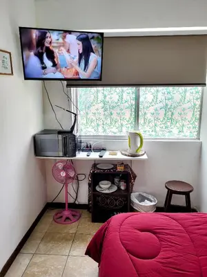 a bedroom with a bed and a flat screen tv at Private Cozy room with batroom in Miraflores in Lima