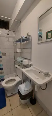 a white bathroom with a toilet and a sink at Private Cozy room with batroom in Miraflores in Lima