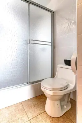 a bathroom with a toilet and a glass shower at Apartamentos Estela en Alameda colonial - 5km Aeropuerto Jorge Chávez in Lima