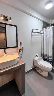 a bathroom with a toilet and a sink and a mirror at Magic Packer Hostel in Cusco