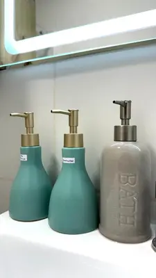 two soap dispensers sitting on a shelf in a bathroom at APARTAMENTO KELVIN - Edificio ON APARTMENTS in Lima