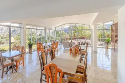 a dining room with tables and chairs and windows at Suite Panorámico 304 in Urubamba
