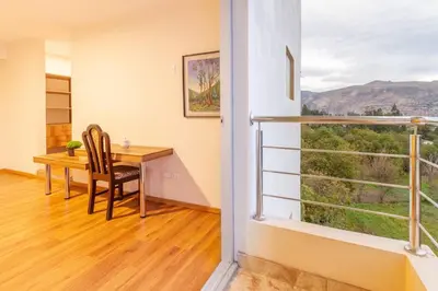 a dining room with a table and a balcony at Suite Panorámico 304 in Urubamba