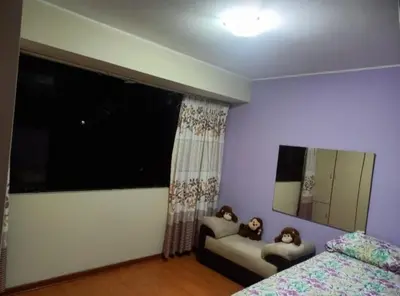a bedroom with a bed and a large window at Frente a hermoso Parque Pueblo Libre in Lima
