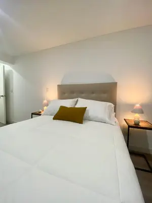 a white bed in a room with two lamps at Amazing 2BR in Barranco in front of CENTRAL restaurant in Lima