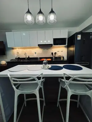 a kitchen with a white counter and two chairs at Amazing 2BR in Barranco in front of CENTRAL restaurant in Lima