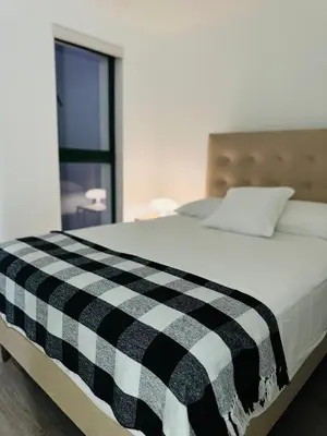 a bed with a black and white checkered blanket on it at Amazing 2BR in Barranco in front of CENTRAL restaurant in Lima