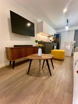a living room with a table and a flat screen tv at Amazing 2BR in Barranco in front of CENTRAL restaurant in Lima