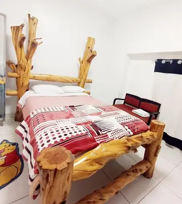a bedroom with a wooden bed with a red and white quilt at Bellavista in Lima