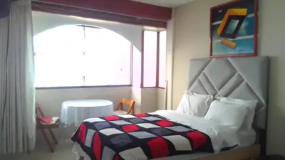 a bedroom with a bed with a checkered blanket at Bellavista in Lima