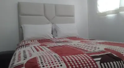 a bed with a red and white quilt on it at Bellavista in Lima