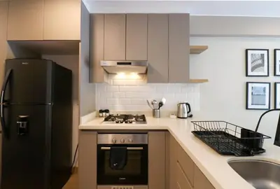 a kitchen with a black refrigerator and a sink at Morada by Wynwood House in Lima